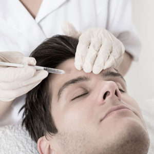Young Man receiving botox injection from doctor